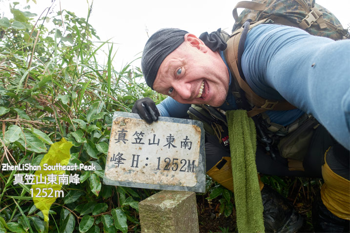 Man holding sign with Chinese characters - triangulation stone - hiker