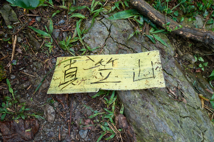 Yellow sign with three Chinese characters lying on ground