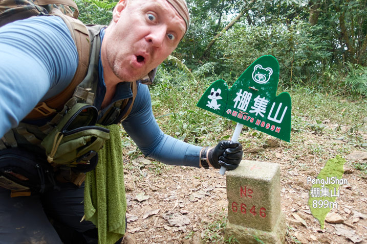 Man holding green sign near PengJiShan - 棚集山 triangulation stone