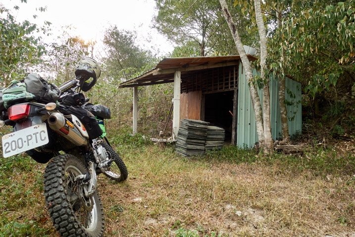 Motorcycle parked near a small shack on mountain