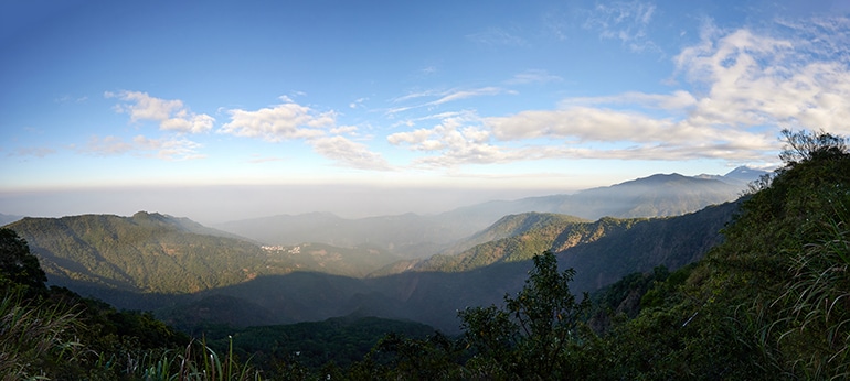 Panoramic view of mountains - blue sky and white clouds - village in distance