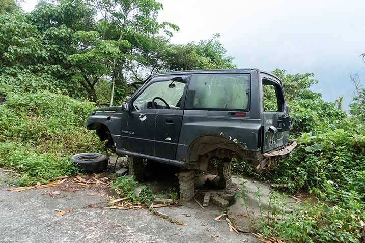 Abandoned 4x4 on blocks on side of mountain road